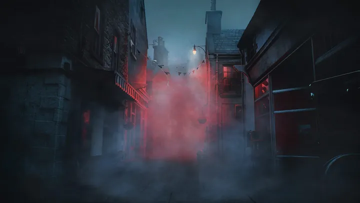 Una estrecha calle de pueblo al anochecer, envuelta en niebla iluminada de rojo bajo una única farola
